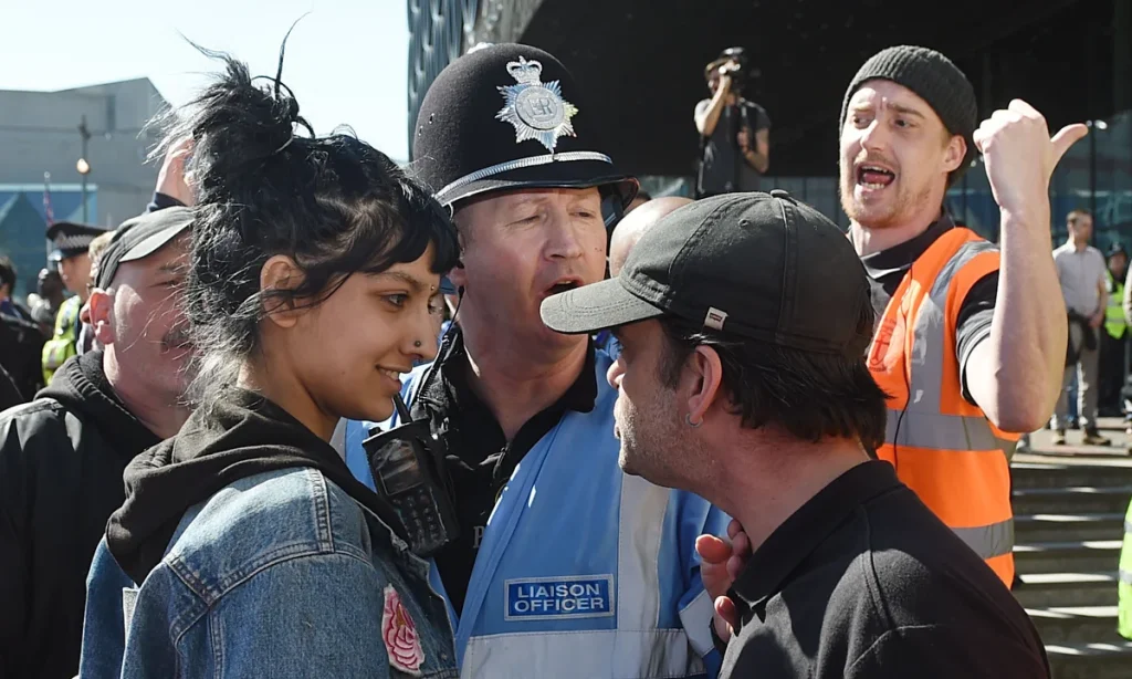 Saffiyah Khan standing calmly in front of an English Defence League protester in Birmingham, 2017.